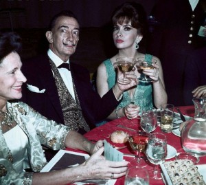 02 Mar 1965 --- Original caption: Moustached artist Salvador Dali and lovely Gina Lollobrigida raise glasses together here at a party following the premier of The Sound of Music held at the Americana Hotel.  Gala Salvador is seated next to the artist. --- Image by © Bettmann/CORBIS